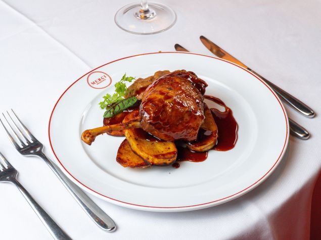 Sugestão do Merci Brasserie é um Confit de Canard preparado com coxa e sobrecoxa de pato confit, batata, cogumelos paris e molho de laranja • Lucas Alvim